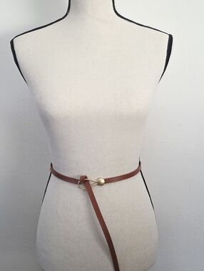 Thin brown belt with gold circular buckle